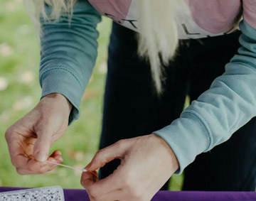 hands making a bracelet with crafft materials