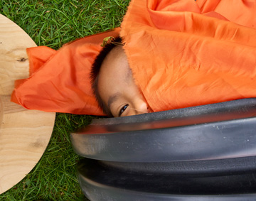 a baby lying on a bright orange carpet