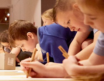 3 children studying wallpaper on display in a gallery space