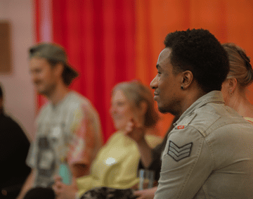 A gathering of people inside a red curtained room