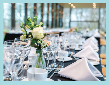 a table in an elegant cafe space set for service with flowers