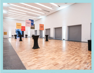 an empty gallery space set up for an event with tables