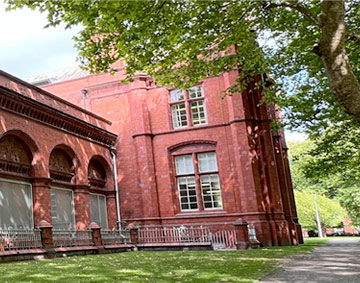 exterior of the Whitworth showing red brick walls and the park with trees