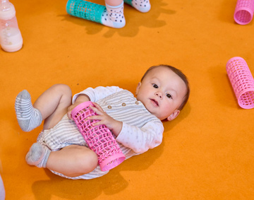 a baby playing on a brightly coloured background