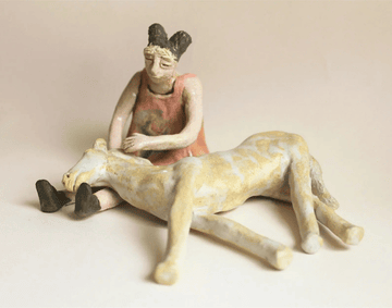 A ceramic figure caressing a dog