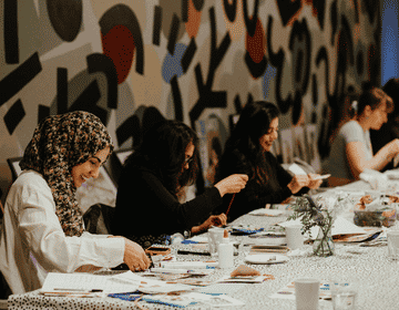 A group of midwives and maternity healthcare professionals crafting around a table