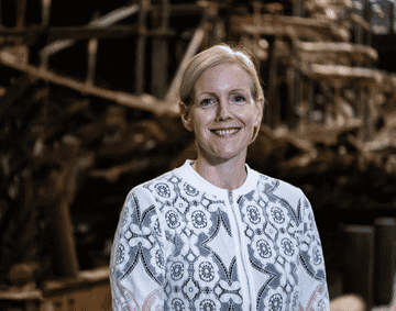 A photograph of Eleanor Schofield in front the Mary Rose