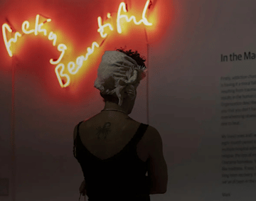 A woman stood in front of a neon sign.