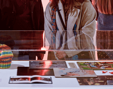 A group of people stood in front of a display case containing vinyl records. 