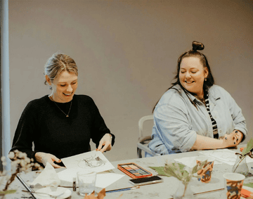 Two workshop participants creating artwork