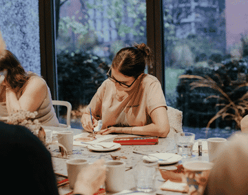 A person wearing a pink shirt crafting in the Garden Studio