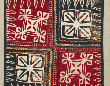 A red and green embroidered cushion cover