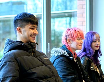 Image of three young people sitting down, dressed casually