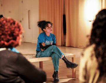 A woman sits on a manji in a large room